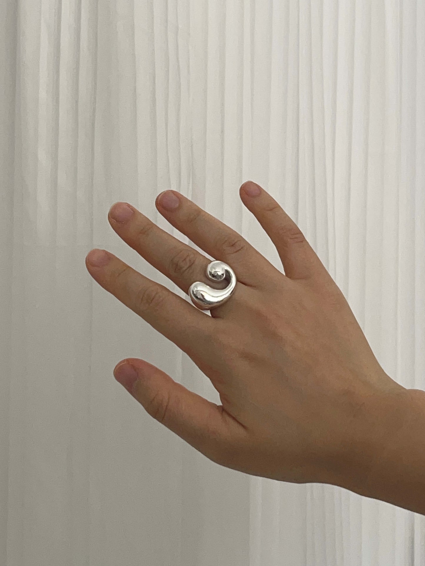 Sterling silver sculptural statement ring with a fluid spiral form, worn on hand. Handmade by LEAP STUDIO and designed to capture the feeling of motion.