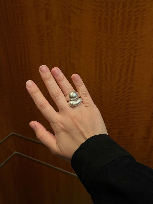 Sculptural sterling silver Orb Ring worn on hand, showcasing its soft dome shape and satin finish.