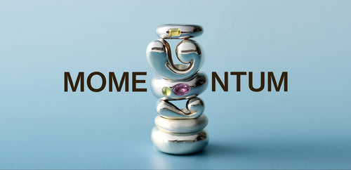 Stack of handmade sculptural silver rings with colorful gemstones spelling MOMENTUM on a light blue background – LEAP STUDIO jewelry collection banner